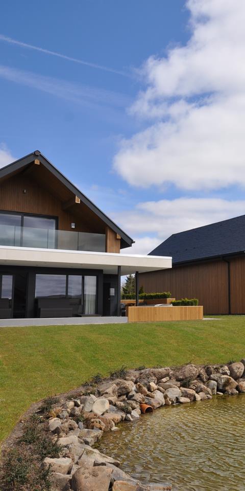 A photograph showing the exterior design of two of the lodges at Lochside, near the loch.