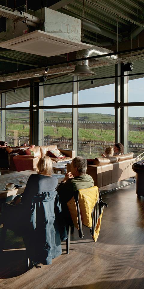 Photograph of Lagg Distillery, showing the restaurant area and customers enjoying the view out to the sea.