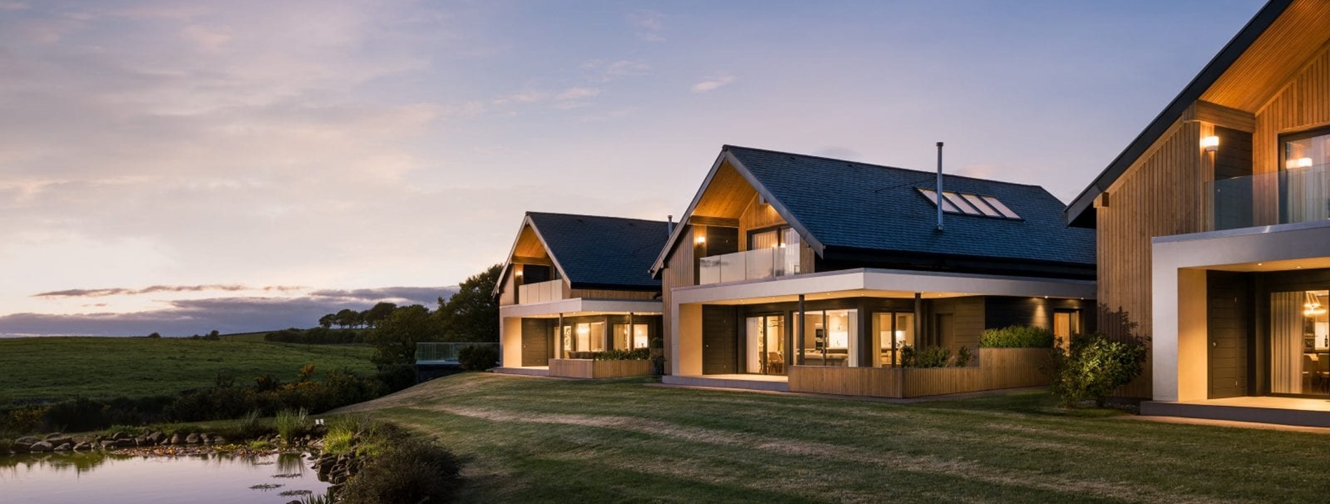 A panoramic view of the Lochside lodges at dusk.