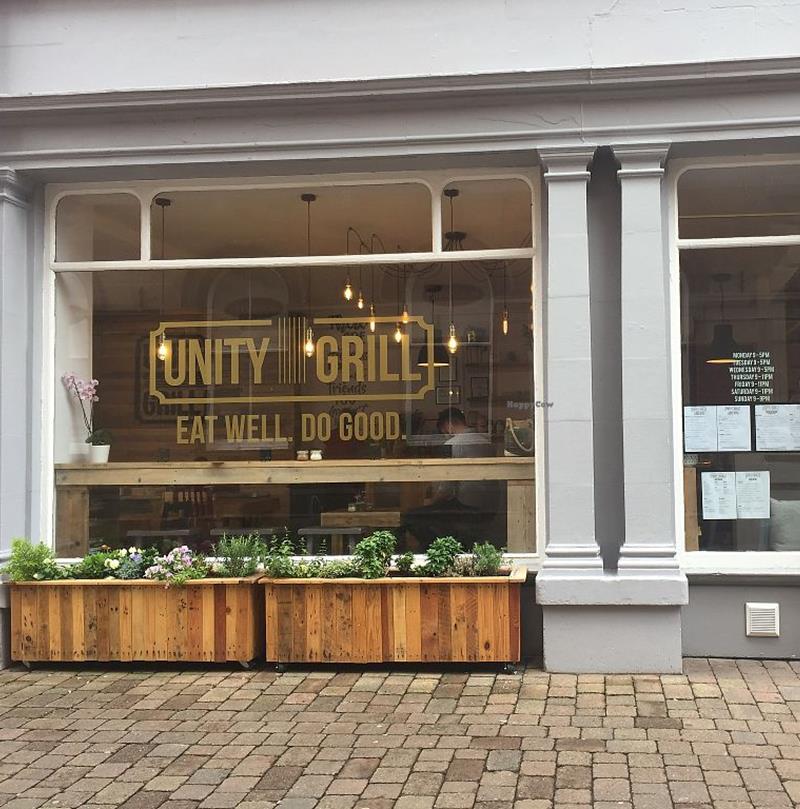 A sunny photograph of Unity Grill from outside looking in.