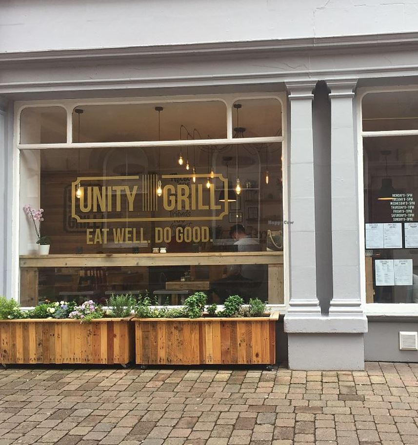 A sunny photograph of Unity Grill from outside looking in.